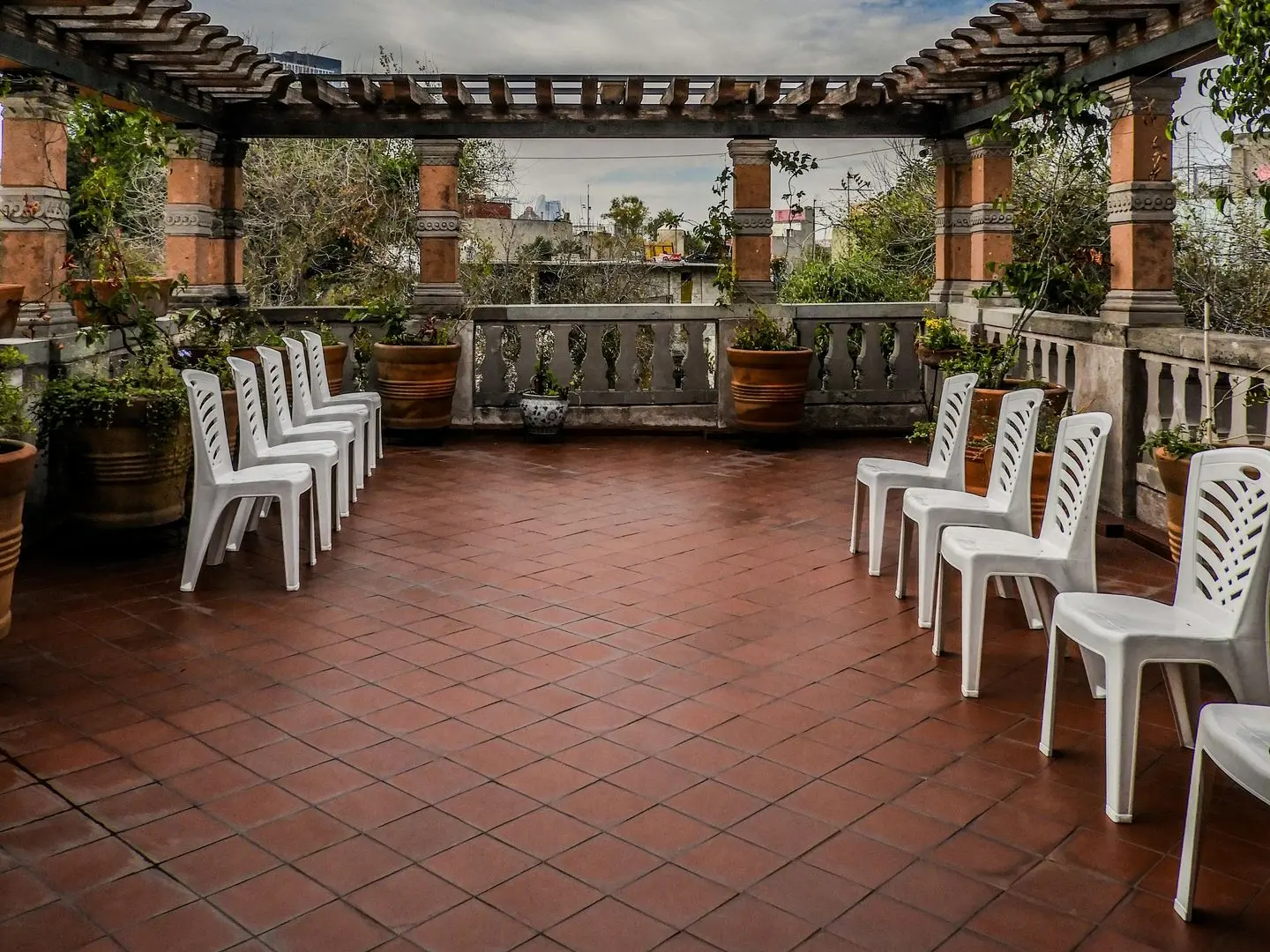 Terraza de baldosas con sillas blancas