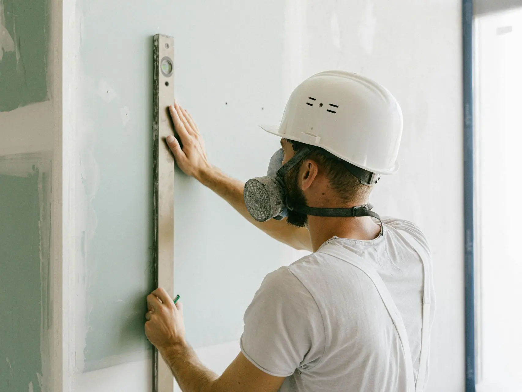 Operario con nivelador en una pared