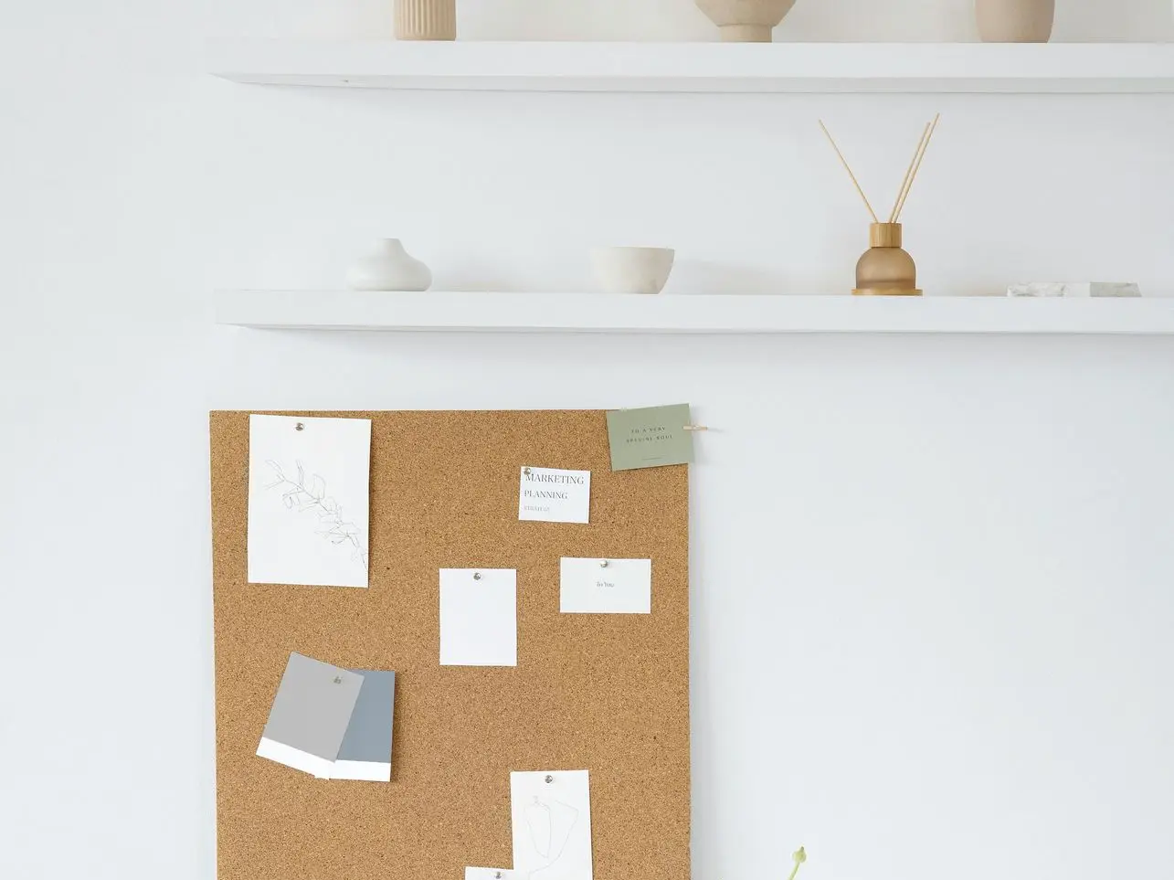 Estantería con objetos decorativos y corcho de pared con apuntes