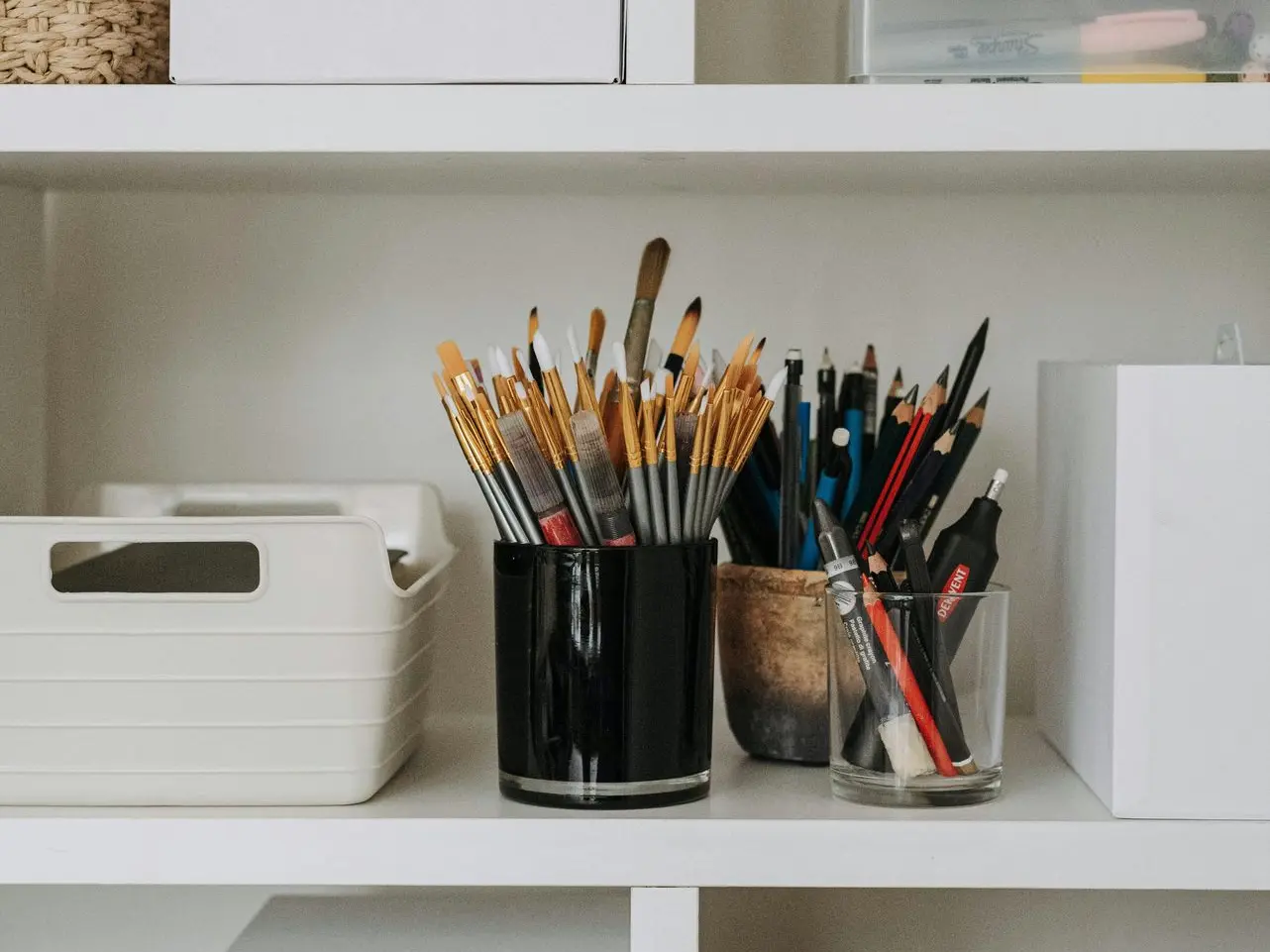 Estantería con botes de pinceles y lápices