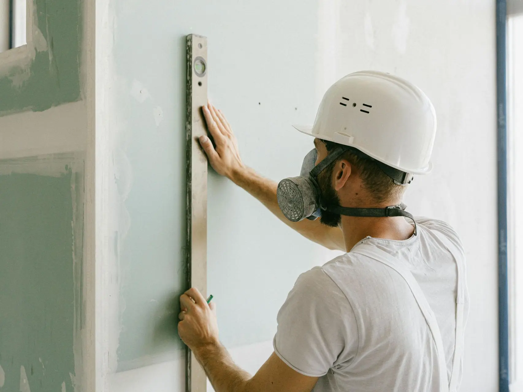 Obrero usando un nivelador en una pared